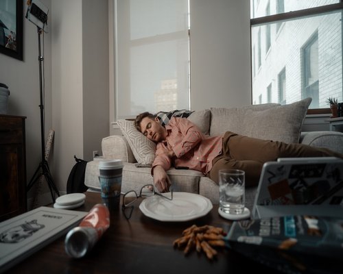 Person relaxing on a sofa looking tired after a long day